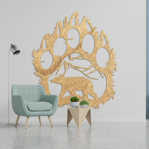 Drewniany wizerunek śladu stopy niedźwiedzia, wewnątrz którego wyrzeźbiona jest sylwetka niedźwiedzia spacerującego pod górami.