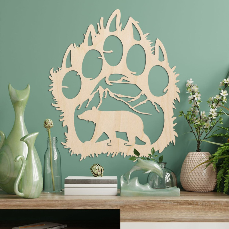 Kontrastująca sylwetka śladu niedźwiedzia, wewnątrz którego widać pasmo górskie i postać niedźwiedzia idącego naprzód.