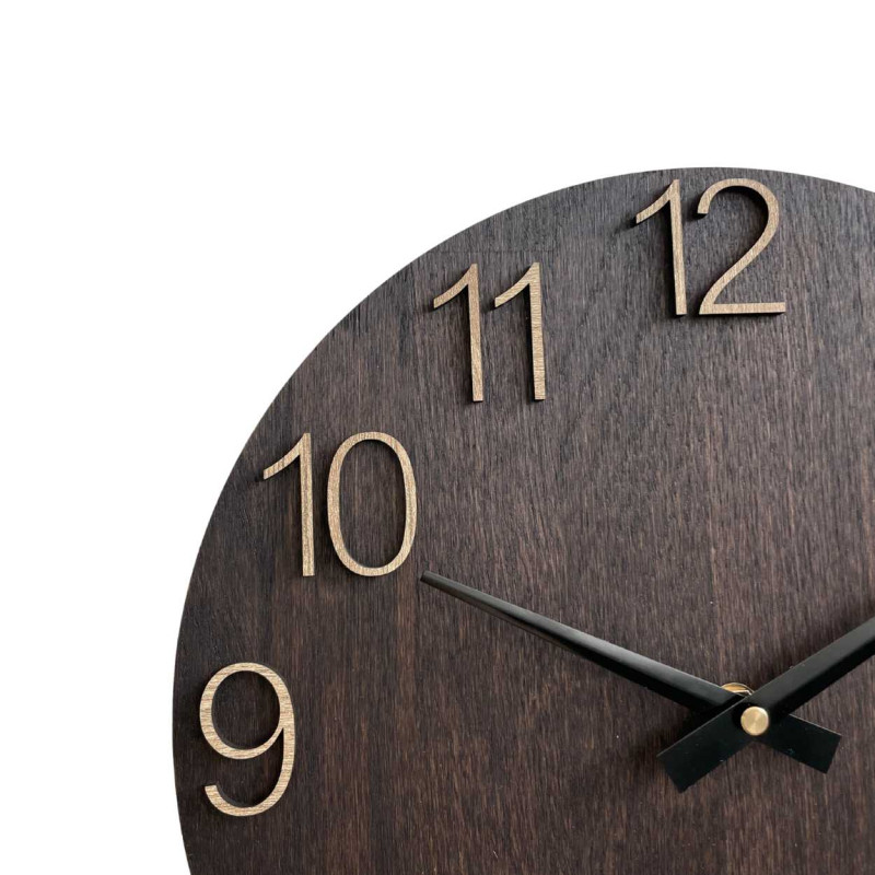 Drewniany zegar ścienny z rzeźbionymi cyframi i metalowymi wskazówkami.