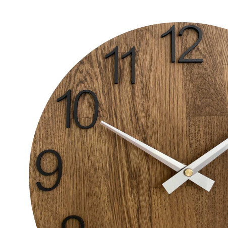 Okrągły zegar z ozdobnym wycięciem w środku i delikatnym wzorem drewna. Okrągły zegar z ozdobnym wycięciem w środku i delikatnym wzorem drewna.