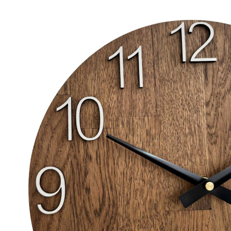 Rzeźbiony drewniany zegar z prostą tarczą i minimalistycznym wzornictwem. Rzeźbiony drewniany zegar z prostą tarczą i minimalistycznym wzornictwem.