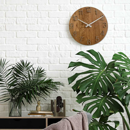 Okrągły zegar z ozdobnym wycięciem w środku i delikatnym wzorem drewna.